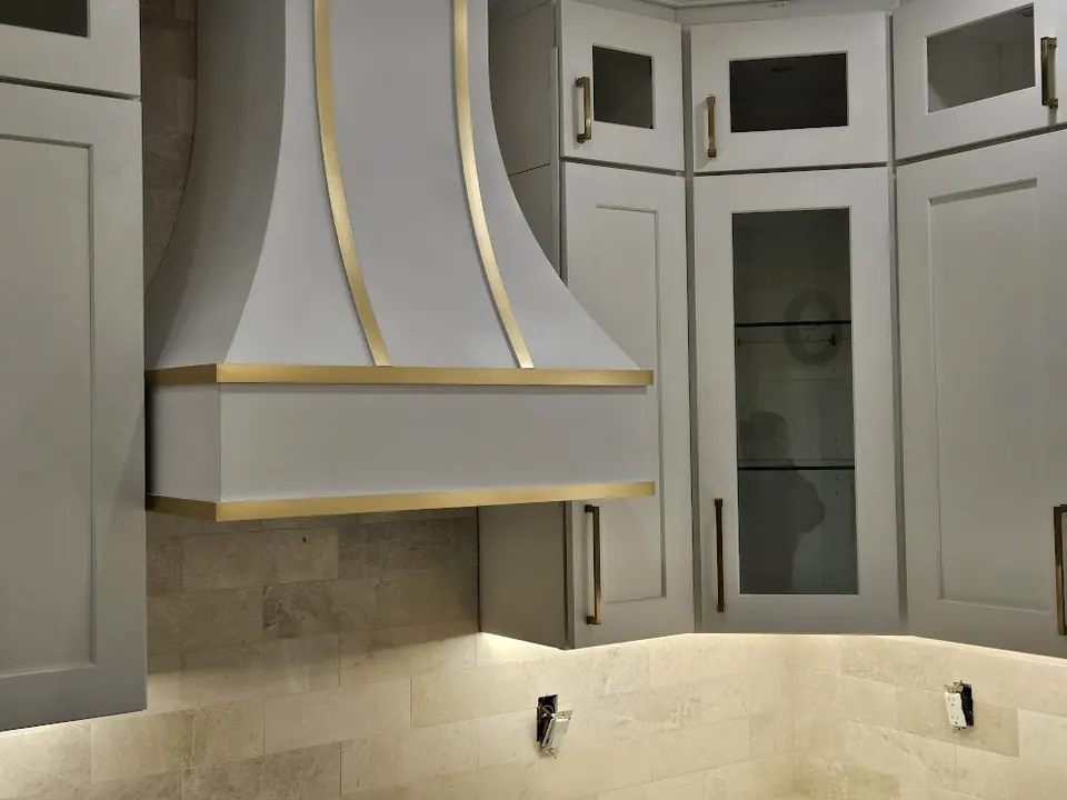 Custom gray range hood with brass trim