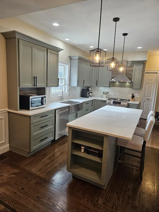 Sage green kitchen island with lantern pendants