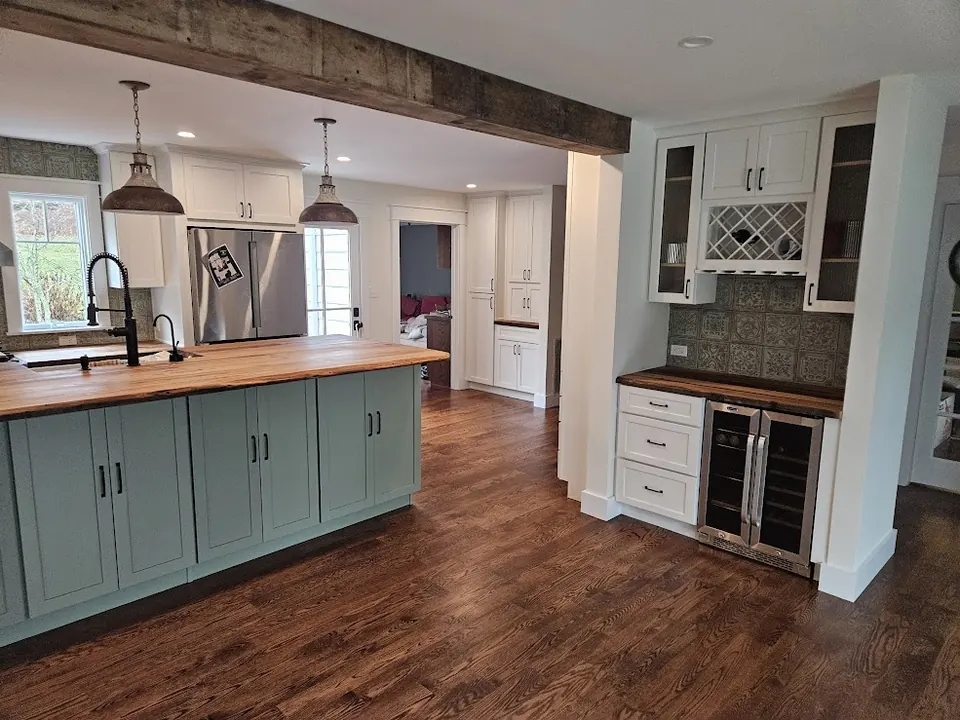 Open kitchen with sage green island and built-in wine bar
