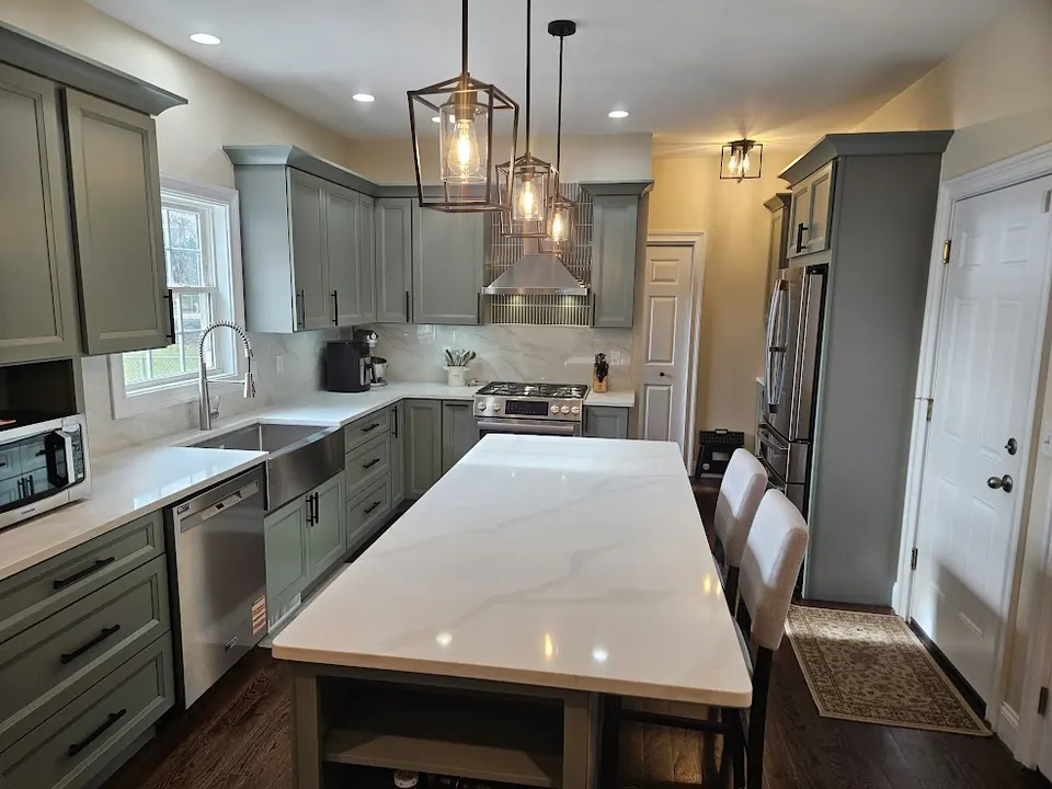Sage green shaker kitchen with long quartz island