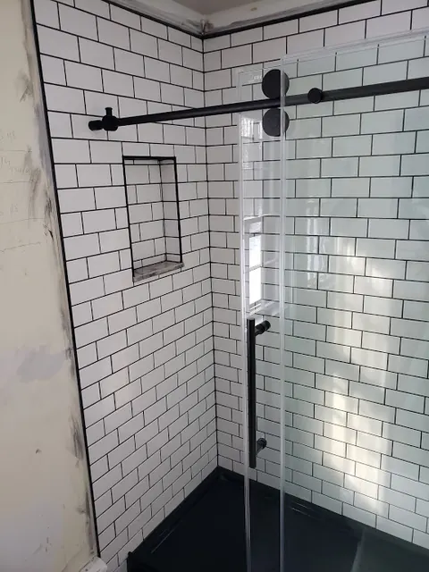 White subway tile shower with black grout