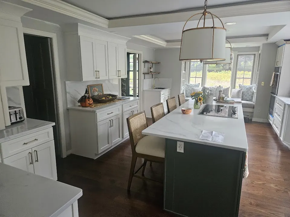 Two-tone kitchen with dark green island and drum pendant