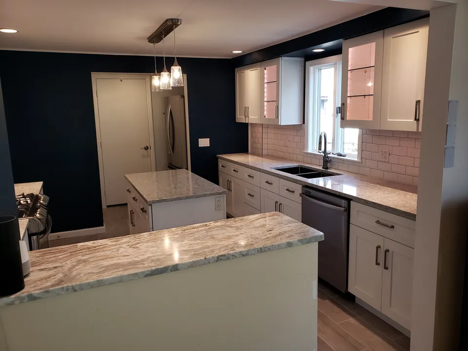 White kitchen with navy walls and quartzite island